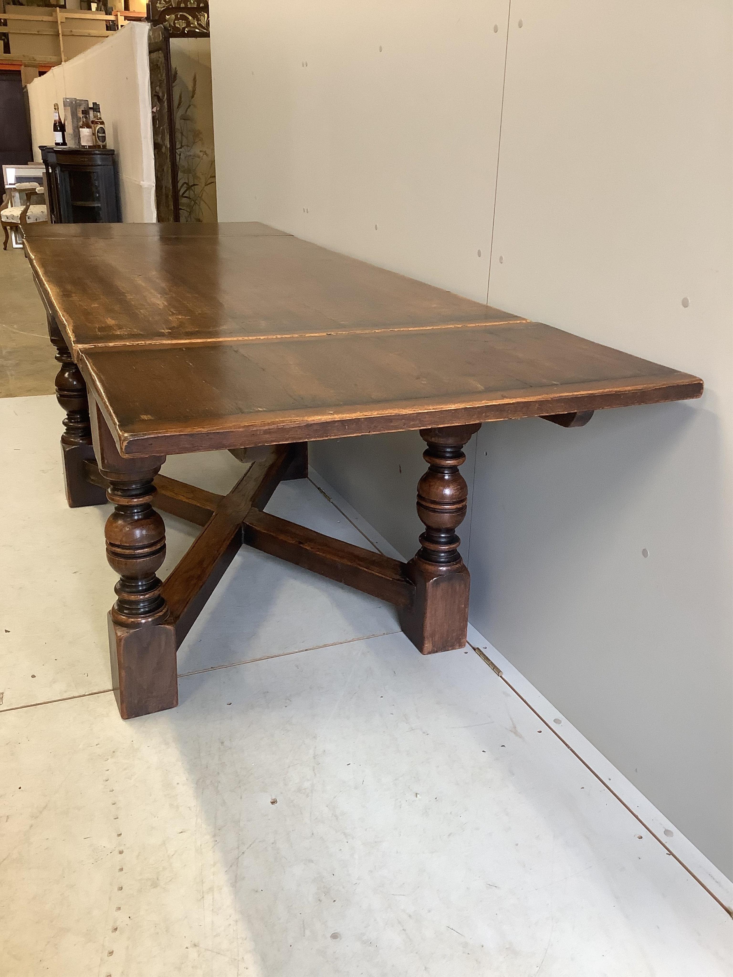 An 18th century style rectangular oak draw leaf refectory dining table, width 244cm extended, depth 85cm, height 79cm together with seven caned oak dining chairs, two with arms. Condition - fair to good